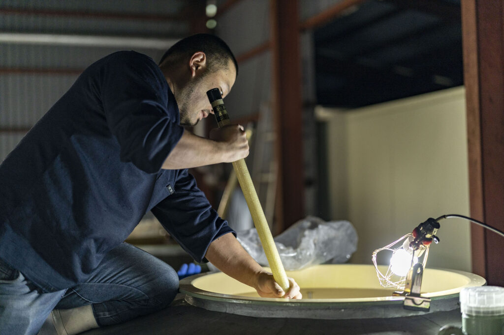 Koji, steamed rice, and water are combined and fermented to create moromi, the mash that becomes Japanese sake. The temperature of the moromi is stabilized through the process of 'kai-ire,' or repeated stirring with paddles.